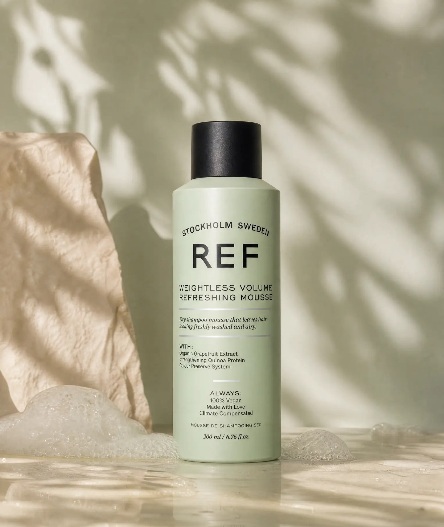 Product still - volume mousse on stone with foam and leaf shadow, AI generated and art directed by me