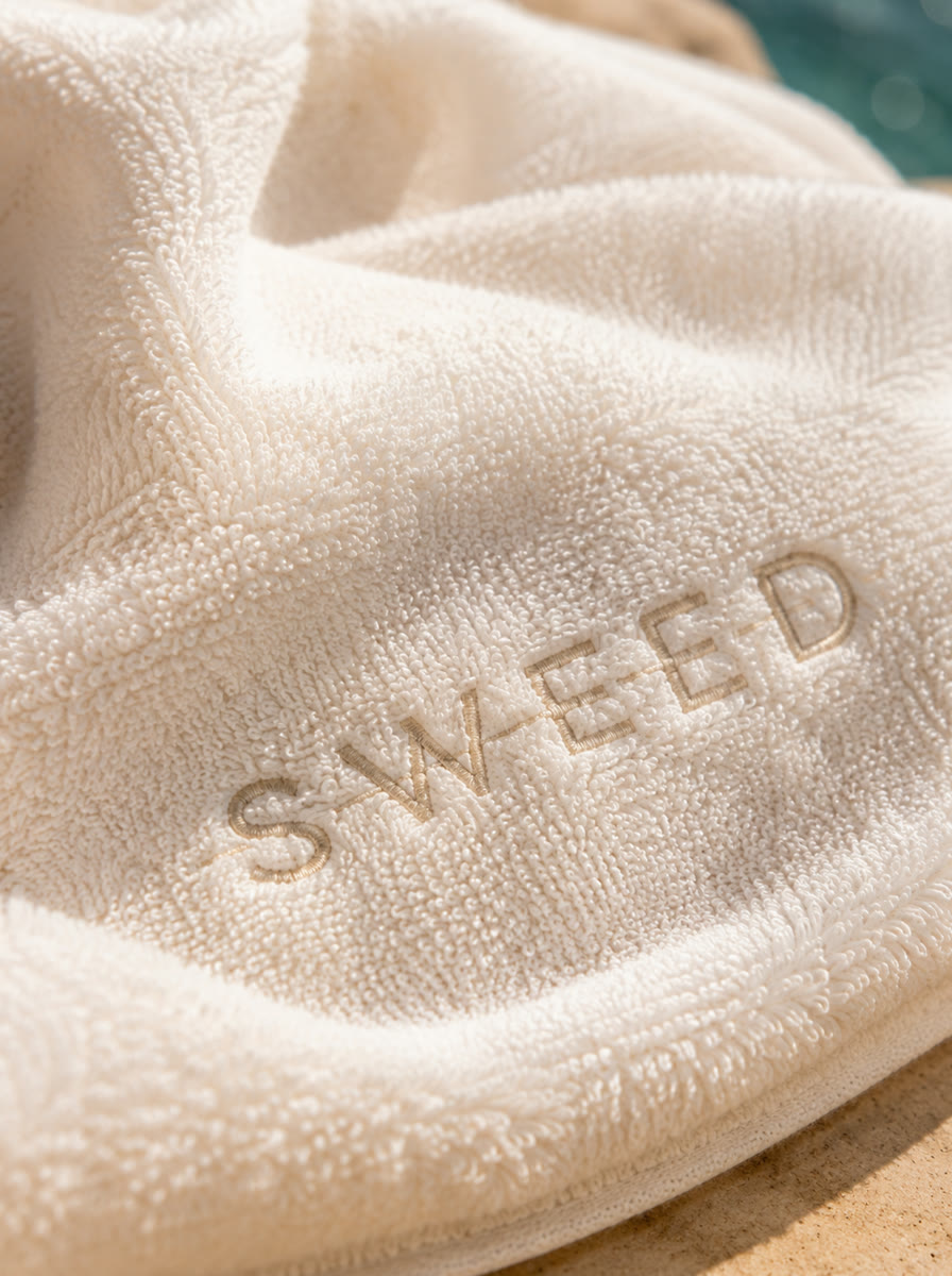 Texture still - embroidered towel in poolside light, AI generated and art directed by me